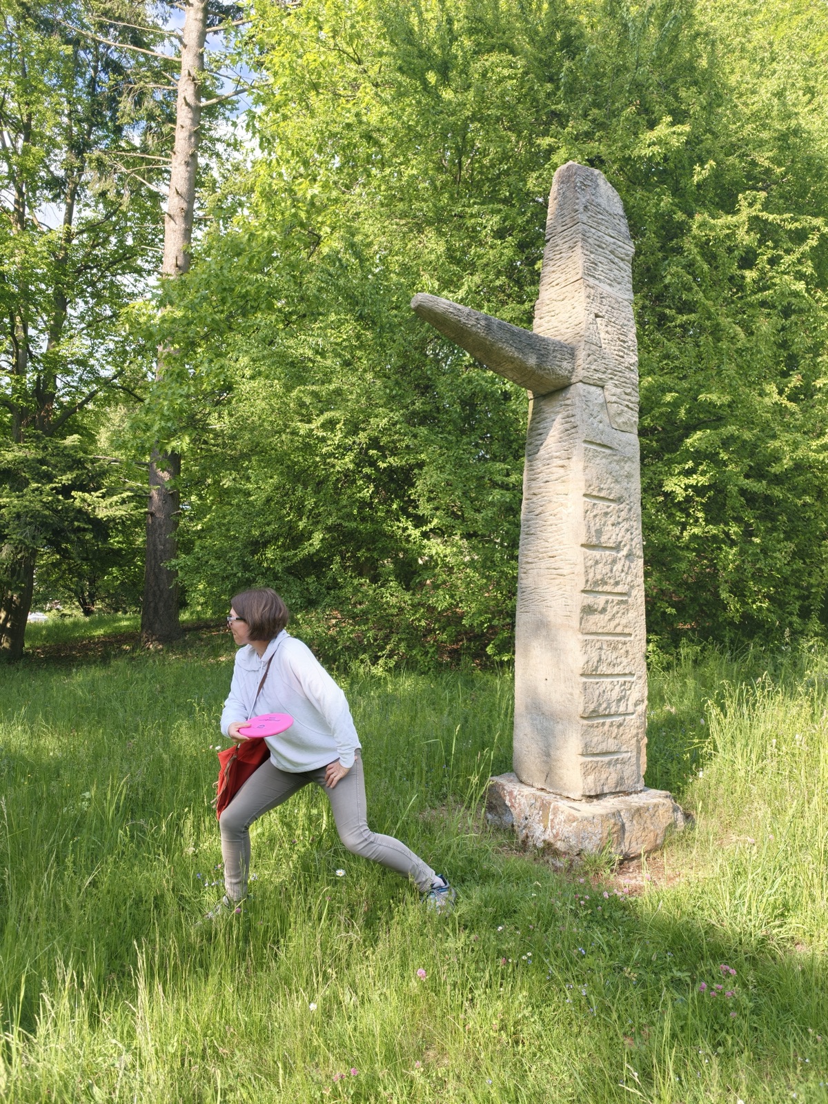 Hráčka s diskem u pískovcové sochy v Sochařském parku